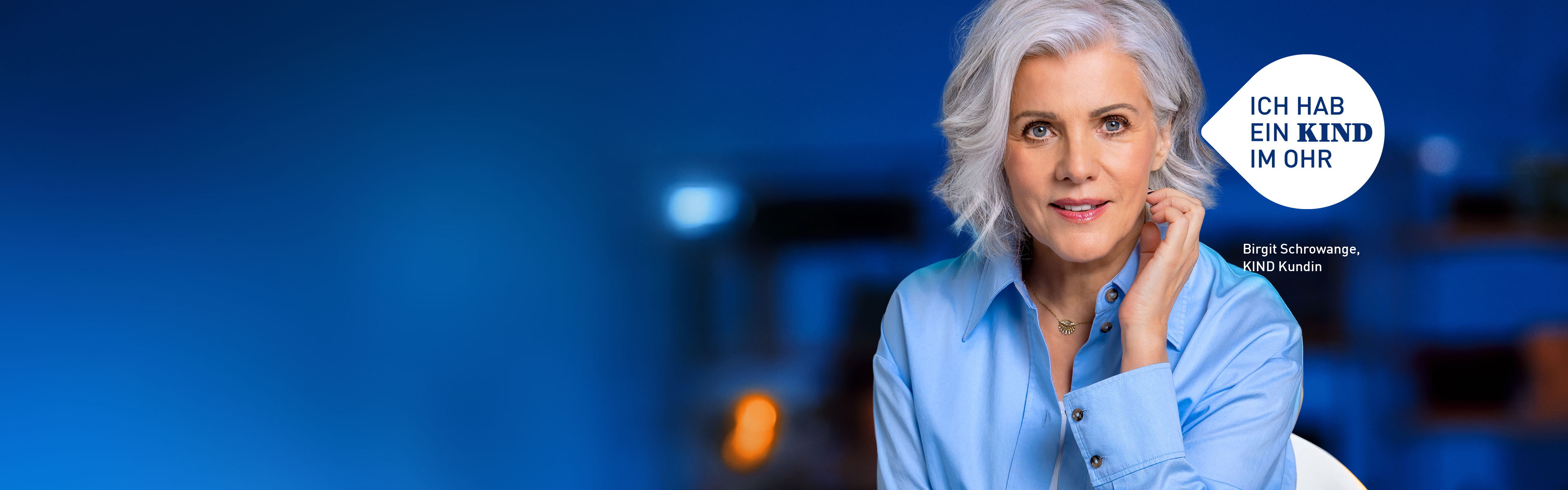 Moderatorin Birgit Schrowange sitzt auf einem Stuhl, hält ihre linke Hand unterhalb des linken Ohres, dazu eine Blase mit den Botschaft "ich hab ein KIND im Ohr"