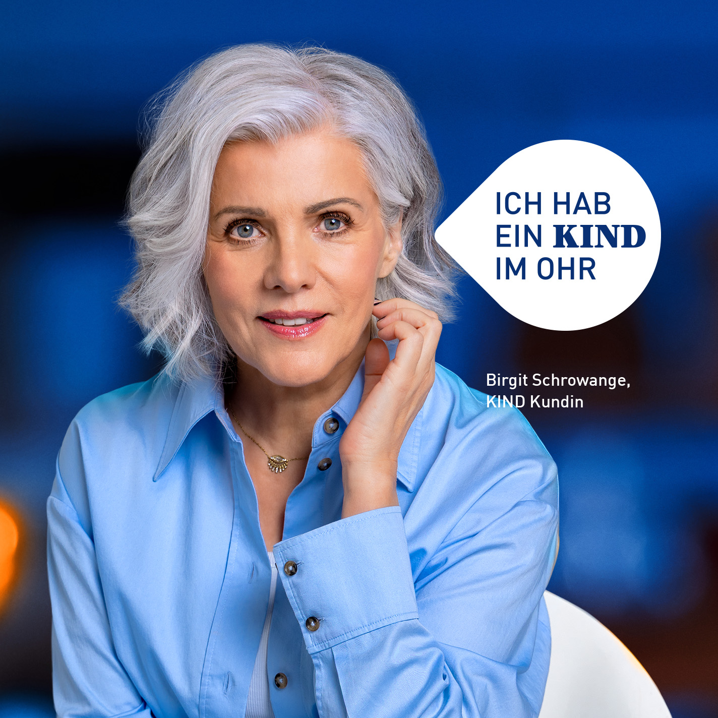 Moderatorin Birgit Schrowange sitzt auf einem Stuhl, hält ihre linke Hand unterhalb des linken Ohres, dazu eine Blase mit den Botschaft "ich hab ein KIND im Ohr"